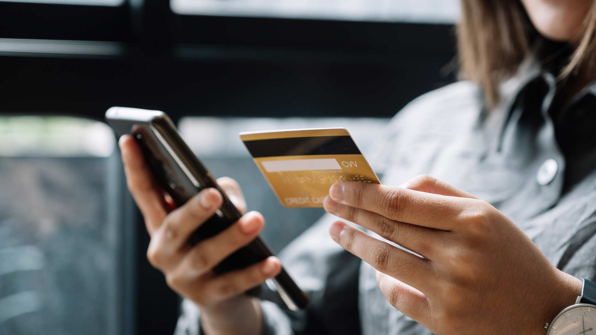 Pessoa utilizando smartphone e cartão de crédito para transação digital, representando soluções de smart bank com serviços financeiros ágeis, conectados e centrados no usuário.